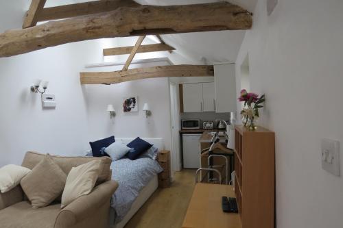 a living room with a couch and a kitchen at The Old Stables, Whitehall Farmhouse, Oakington in Cambridge