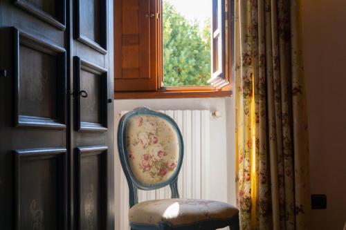 a chair sitting in a room next to a window at Agriturismo Villa Lugnano Casale Con Piscina Privata in Lugnano