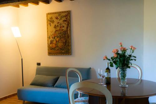 a living room with a couch and a table with a vase of flowers at Agriturismo Villa Lugnano Casale Con Piscina Privata in Lugnano