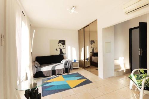 un salon avec un lit et une table en verre dans l'établissement VILLA THETIS 4 pièces, à Antibes