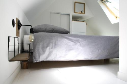 - une chambre avec un lit et une couette grise dans l'établissement TinyHouse LE CONQUET, au Conquet