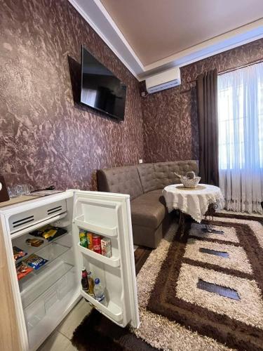 a living room with a couch and a small refrigerator at Hotel Chicago in Umanʼ