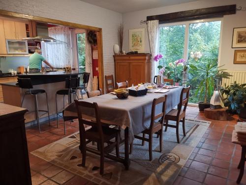 a kitchen with a table and a man in the kitchen at Les Sittelles - Tilff in Esneux