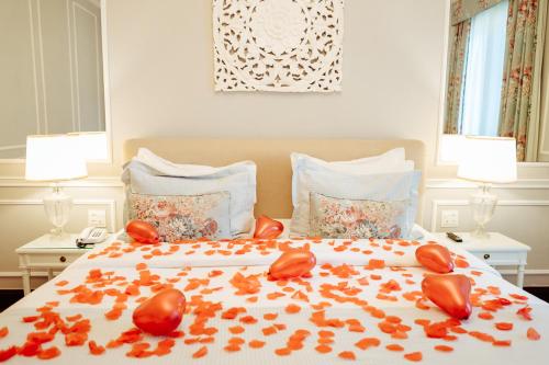 a bedroom with a bed with red leaves on it at Hotel Reggia Catarina in Petrópolis