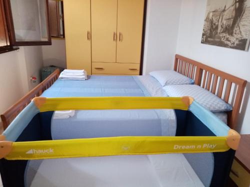 two twin beds in a room with yellow and blue beds at Villa La Pelosa Stintino in Stintino