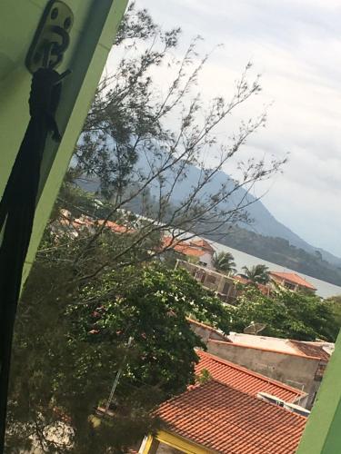 a view of a city with a tree and a mountain at Hotel Aconchego Da Vila in Saquarema