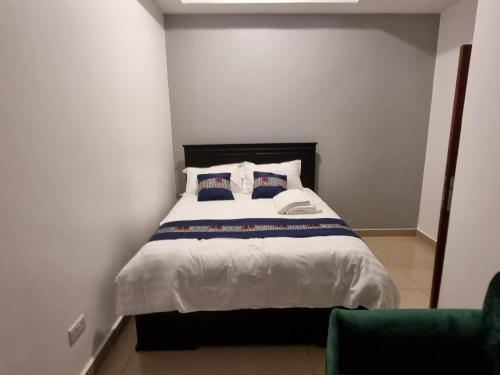 a bedroom with a large bed with two pillows at Eika Suites at Acacia in Kampala