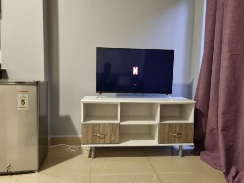 a tv on a stand with a tv on it at Eika Suites at Acacia in Kampala