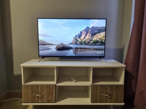 a flat screen tv sitting on top of a cabinet at Eika Suites at Acacia in Kampala