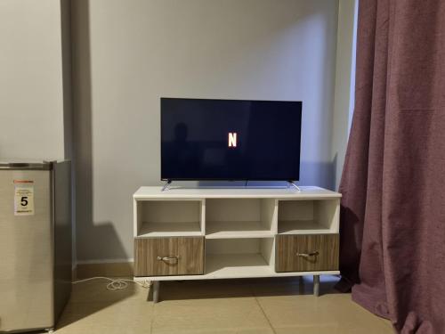 a tv on a stand with a television on it at Eika Suites at Acacia in Kampala