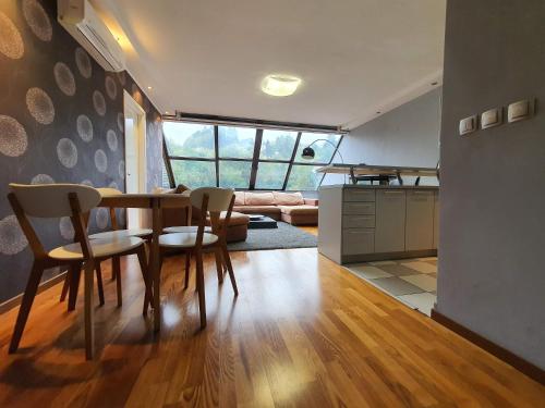 a kitchen and living room with a table and chairs at Amazing Penthouse old town in Sarajevo