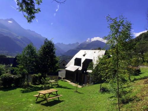 einen Picknicktisch auf einem Feld neben einer Scheune in der Unterkunft Appartement dans chalet avec jardin, vue montagne in Aucun