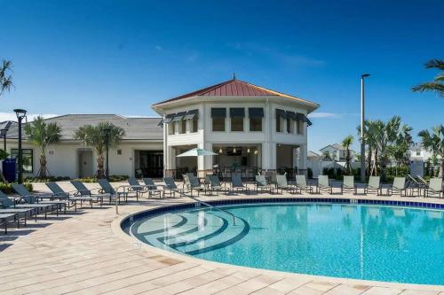 a swimming pool with chairs and a building at NEWLY LISTED Townhouse Storey Lake, Free Waterpark in Kissimmee