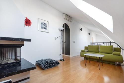 ein Wohnzimmer mit einer grünen Couch und einem Kamin in der Unterkunft Vienna Roof Top Apartment with Terrace, Parking and AC in Wien