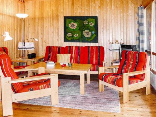 ein Wohnzimmer mit einem Sofa, einem Tisch und Stühlen in der Unterkunft Holiday home HOLMSJÖ II in Troxhult