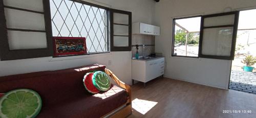 a living room with a couch and two windows at Arazá in Cuchilla Alta