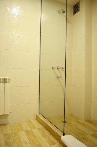 a bathroom with a glass shower with a toilet at Hotel Bait in General Roca