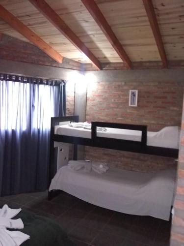 two bunk beds in a room with a brick wall at La Galensa in Trevelín