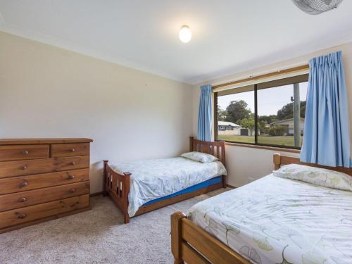 a bedroom with two beds and a dresser and a window at Armorel at Iluka in Iluka