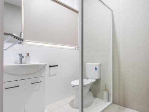 La salle de bains blanche est pourvue de toilettes et d'un lavabo. dans l'établissement Baby Bundjalung, à Iluka