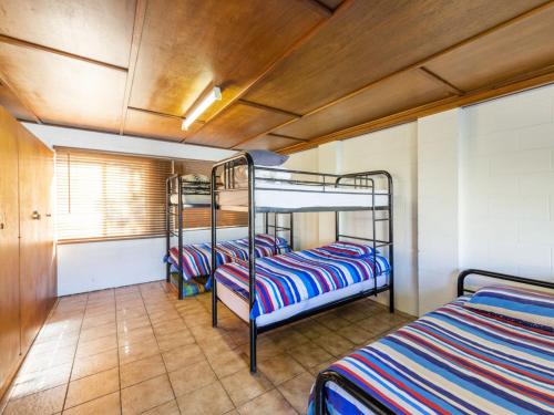 a room with three bunk beds in it at Greenwood House in Iluka