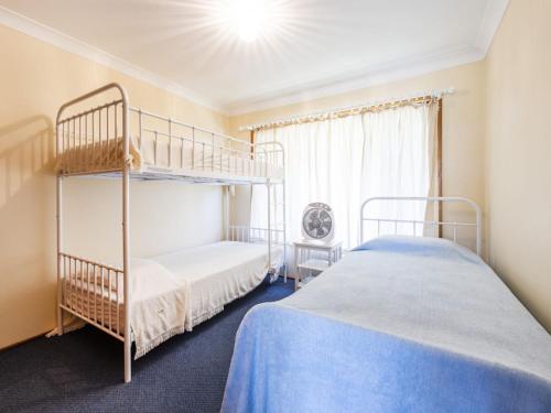a bedroom with two bunk beds and a window at Crowes Nest in Iluka