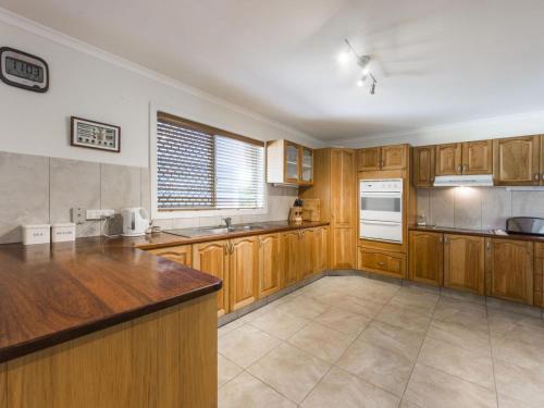 
a kitchen with a sink, stove, refrigerator and a window at Lillypilly in Iluka
