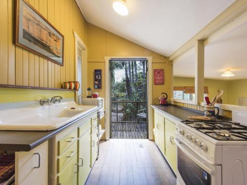 
a kitchen with a refrigerator, stove, sink and dishwasher at little beach house in Iluka
