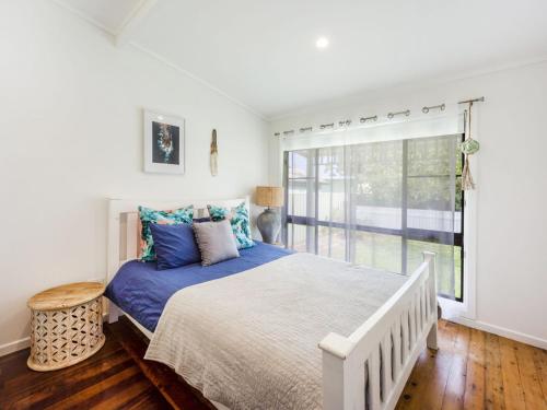 a bedroom with a large bed and a window at My Luka at Iluka in Iluka