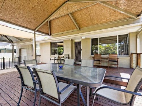 a dining room with a table and chairs on a deck at Tarraloo Iluka NSW in Iluka