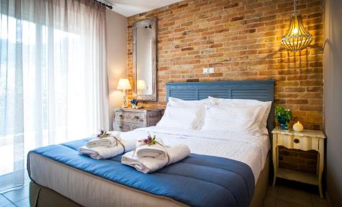 sypialnia z łóżkiem z ręcznikami w obiekcie Villa Teresa Luxury Suites w mieście Limenas
