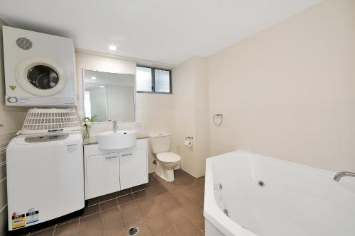 
a bathroom with a sink, toilet and bathtub at The Point Resort in Bargara
