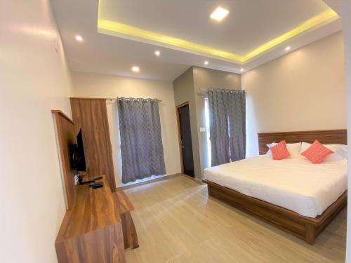 a bedroom with a bed with red pillows on it at Avalon Stays in Ooty
