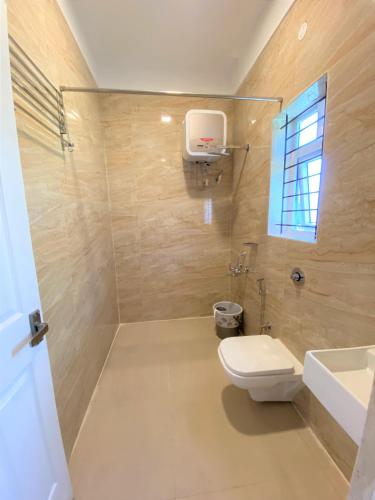 a bathroom with a toilet and a sink at Avalon Stays in Ooty