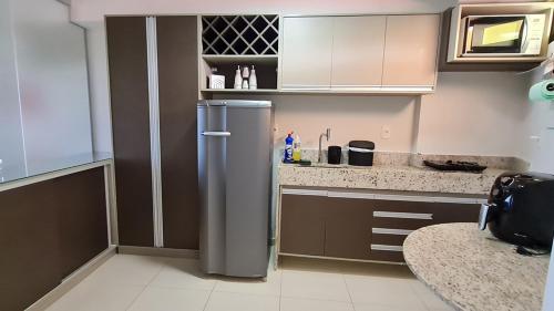 a kitchen with a stainless steel refrigerator in it at Flat Tabatinga Nord, vista para o mar in Conde