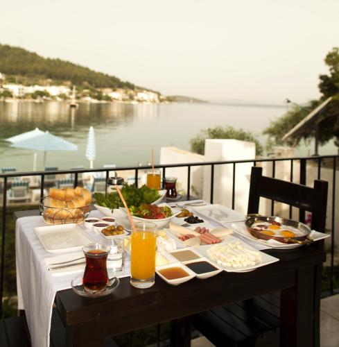 a table with food and drinks and a view of the water at Zena Hotel Bodrum in Guvercinlik