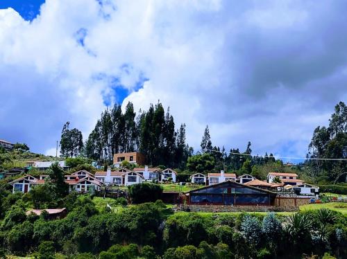 a village on a hill with houses and trees at Hotel Cabañas San Cayetano in Paipa