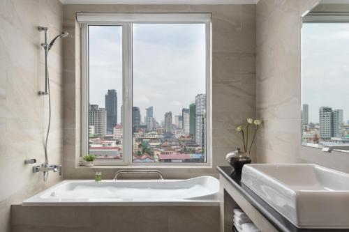 a bathroom with a tub and a large window at Duong Chan Hotel in Phnom Penh
