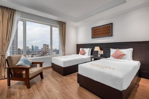Duong Chan Hotel في بنوم بنه: غرفة فندقية بسريرين ونافذة