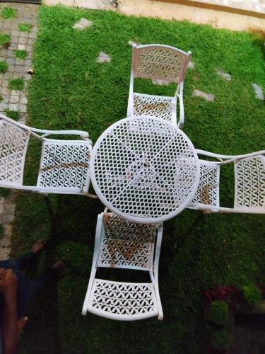 a white table and chairs sitting on the grass at Andorra Tourist Resort Anuradhapura in Anuradhapura