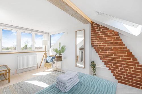 a living room with a brick wall at Seagrass Cottage in Southwold, Stunning Property with Views! in Southwold