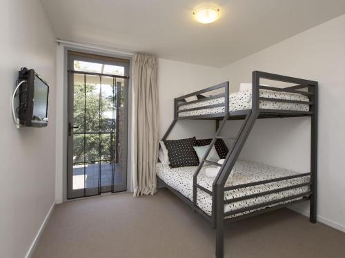 a bedroom with two bunk beds and a window at The Edge Apartment 5 Jindabyne in Jindabyne