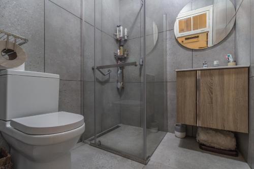a bathroom with a toilet and a glass shower at A Whale's Tale Beach House in Amanzimtoti