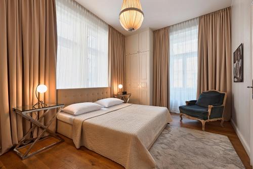 a bedroom with a bed and a chair and windows at 6 rooms in Vienna