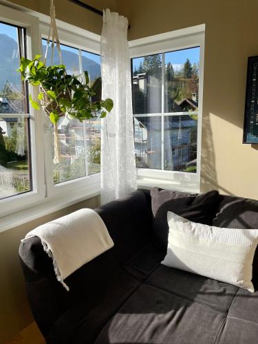 a black couch in a living room with windows at S´Kraftplatzl in Bad Aussee