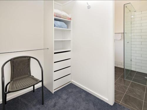 a walk in closet with a chair and a shower at Matilda Spacious centrally located with great lake views in Jindabyne