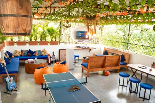 restauracja z pomarańczowymi poduszkami, stołami i krzesłami w obiekcie Jugglers Backpack w mieście Pune