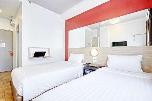 a hotel room with two beds and a mirror at Red Planet Bangkok Asoke - SHA Extra Plus in Bangkok