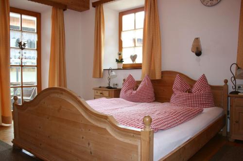 a bedroom with a wooden bed with red pillows at Beim Heiß'n in Staudach-Egerndach