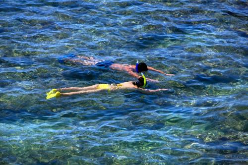 two people are swimming in the water at Mandarin Oriental, Sanya in Sanya